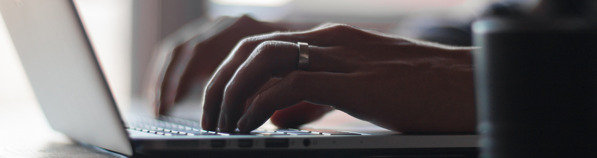 Hands typing on a laptop